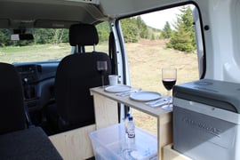 an interior view of the nissan nv200 camper van storage and kitchen essentials